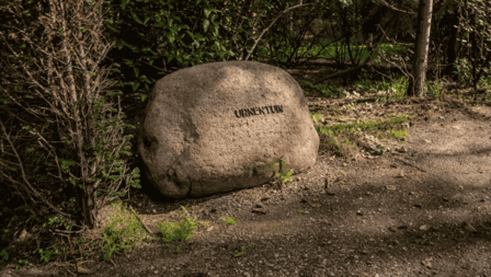 Grote steen met tekst urnentuin